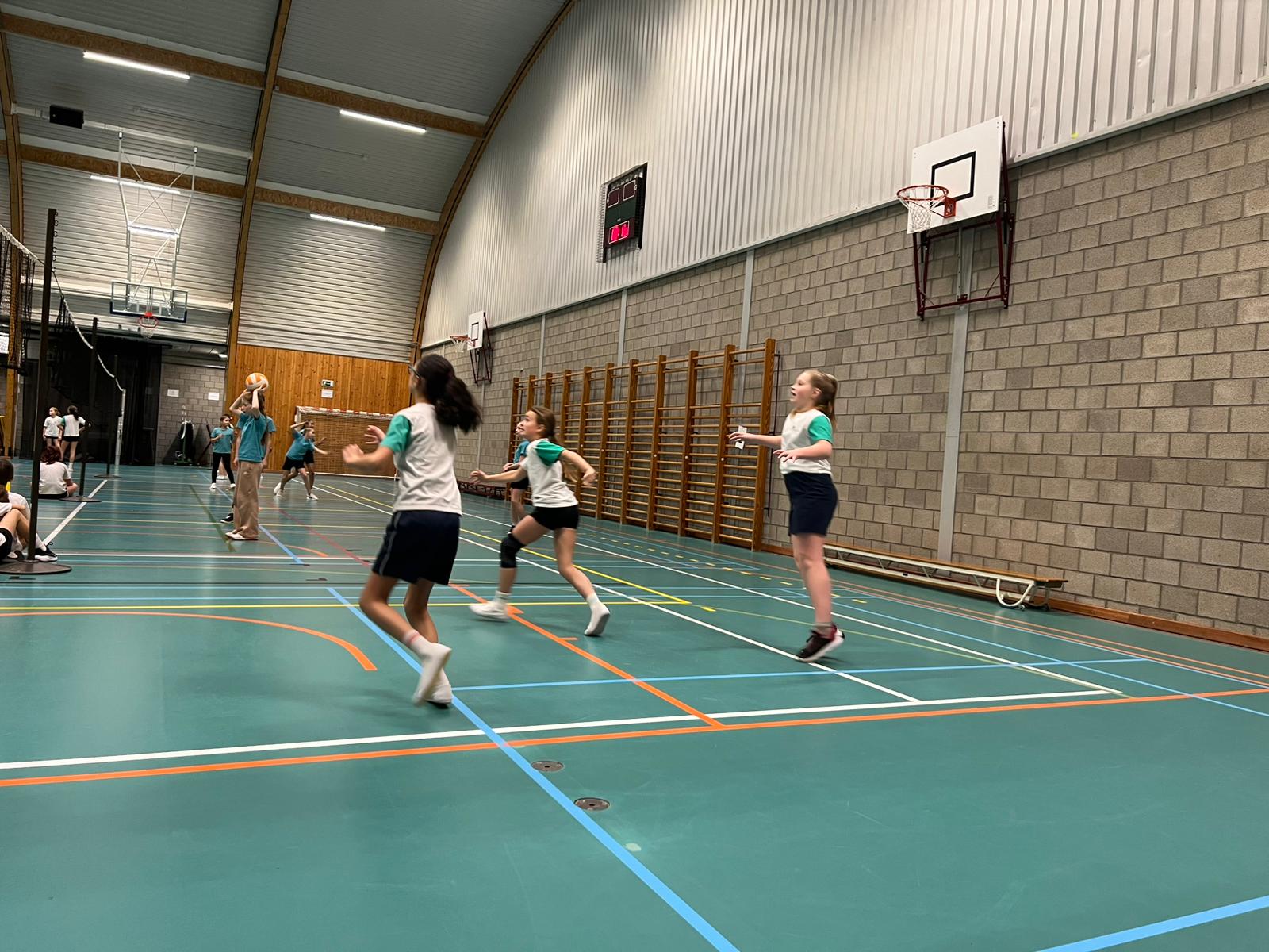 Kinderen spelen netbal. 