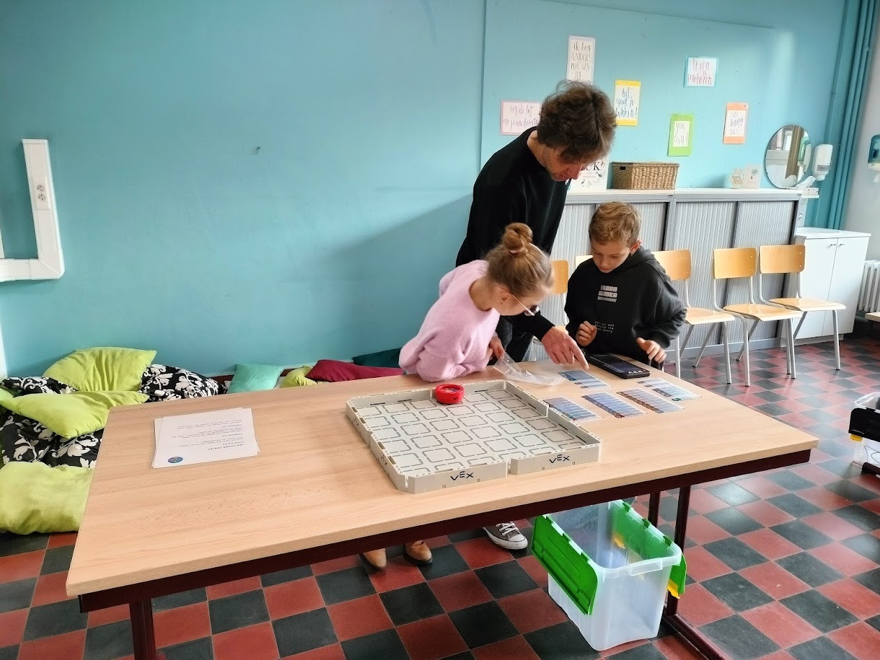 Meester en kinderen programmeren met VEX123.